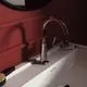 Chromene Waschtischarmatur von Ideal Standard mit einem schlichten, modernen Design. Sichtbare Kreuzgriffe und integrierte Wasserhähne auf einem weißen Waschbecken.
